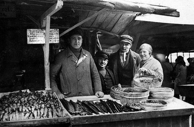Doles zivis Rīgas tirgū. Aiz letes – “Klambaru-Riekstiņu” saimnieks Riekstiņš (otrais no kreisās) un tirgus strādnieki (ap 1928.gadu). Foto – no Daugavas muzeja krājuma