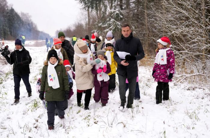 Rīgas pilsētas priekšsēdētājs Mārtiņš Staķis (no labās) un bērnu vokālais ansamblis "Momo" piedalās pasākumā "Rīgas mežu" Tīreļu mežniecībā Olainē, kur izvēlās divas galvenās Rīgas Ziemassvētku egles, kas rotās Doma laukumu un Rātslaukumu. Foto - Paula Čurkste, LETA