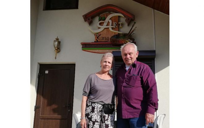 Sandra un Džons Delgalvji pie nama, kas celts kā “JD Art” klubs. Foto – no “JD Art” kluba arhīva