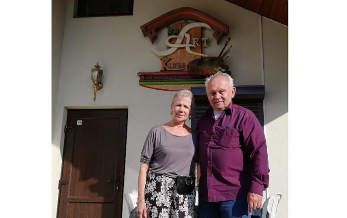 Sandra un Džons Delgalvji pie nama, kas celts kā “JD Art” klubs. Foto – no “JD Art” kluba arhīva