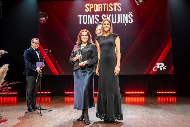 Gada labākā riteņbraucēja balvu Toma Skujiņa vietā saņēma mamma Anita, kurai to pasniedza pasaules čempione pludmales volejbolā Tīna Graudiņa. Foto – Māris Vancevičs