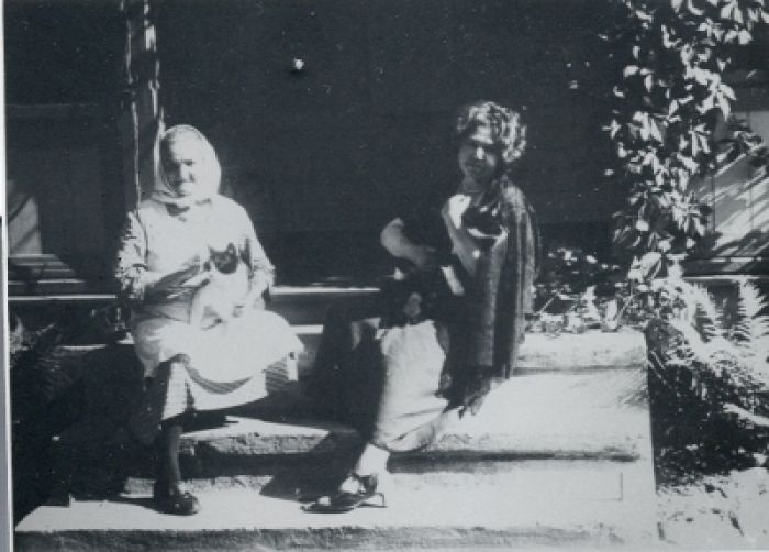 Uz mājas lieveņa Aspazija un mājkalpotāja Anniņa ar kaķiem. Foto no Rakstniecības, teātra un mūzikas muzeja krājuma